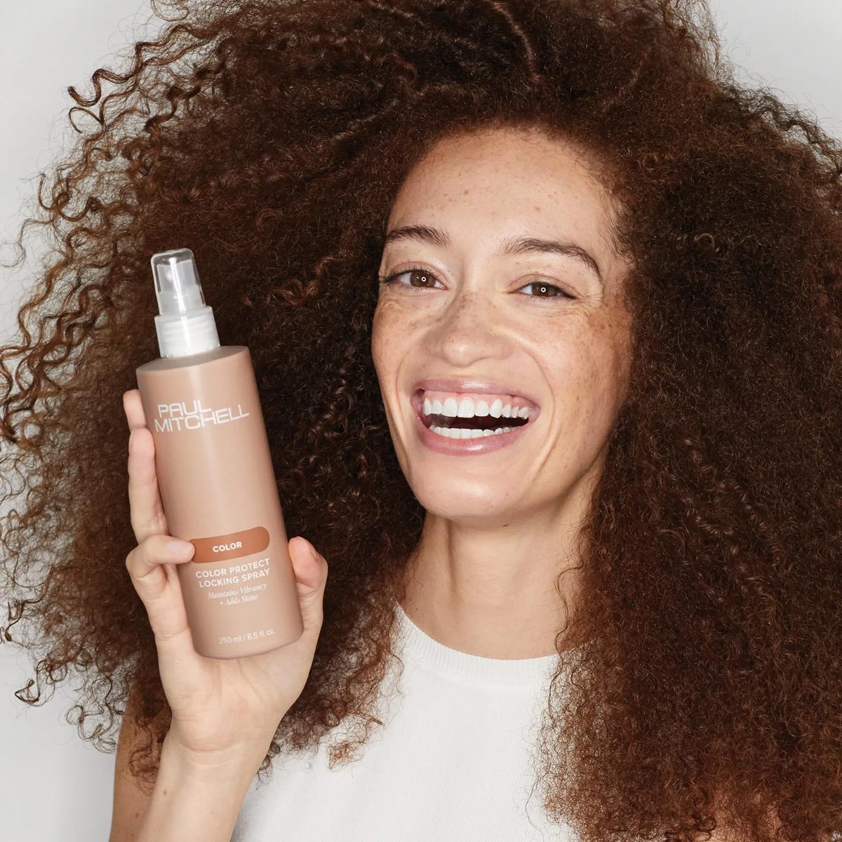 image of woman holding a bottle of Color Protect Locking Spray