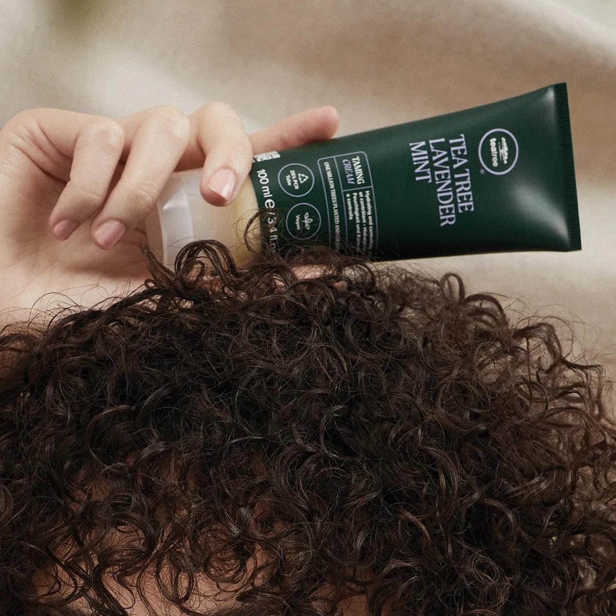image of a model holding a tube of Lavender Mint Taming Cream