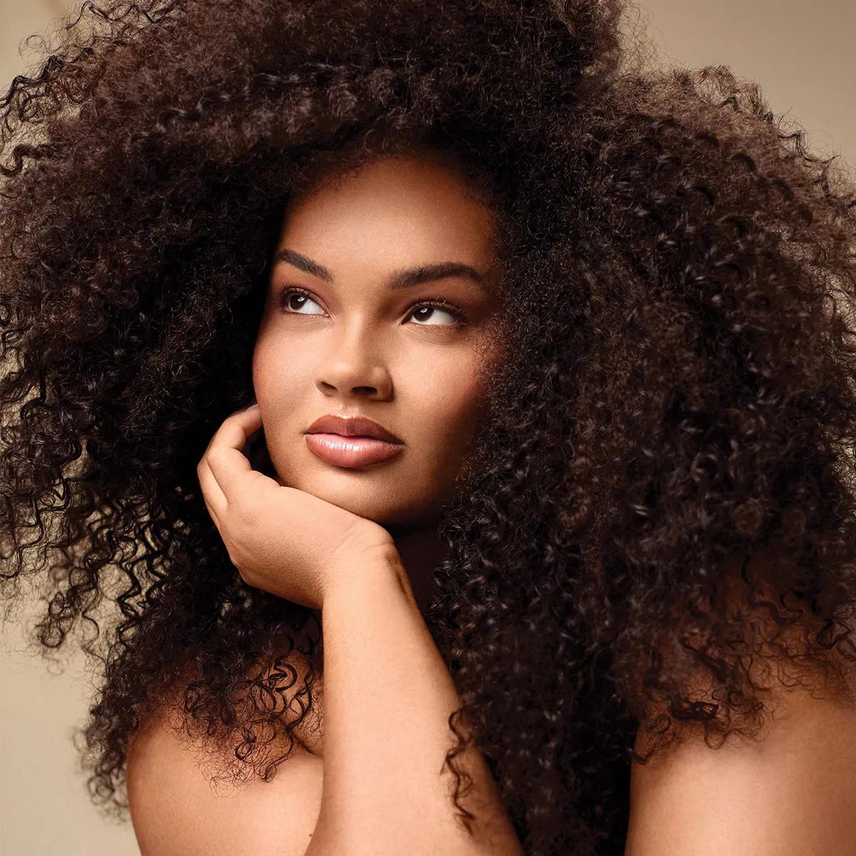 image of a woman with curly, brunette hair pondering intently
