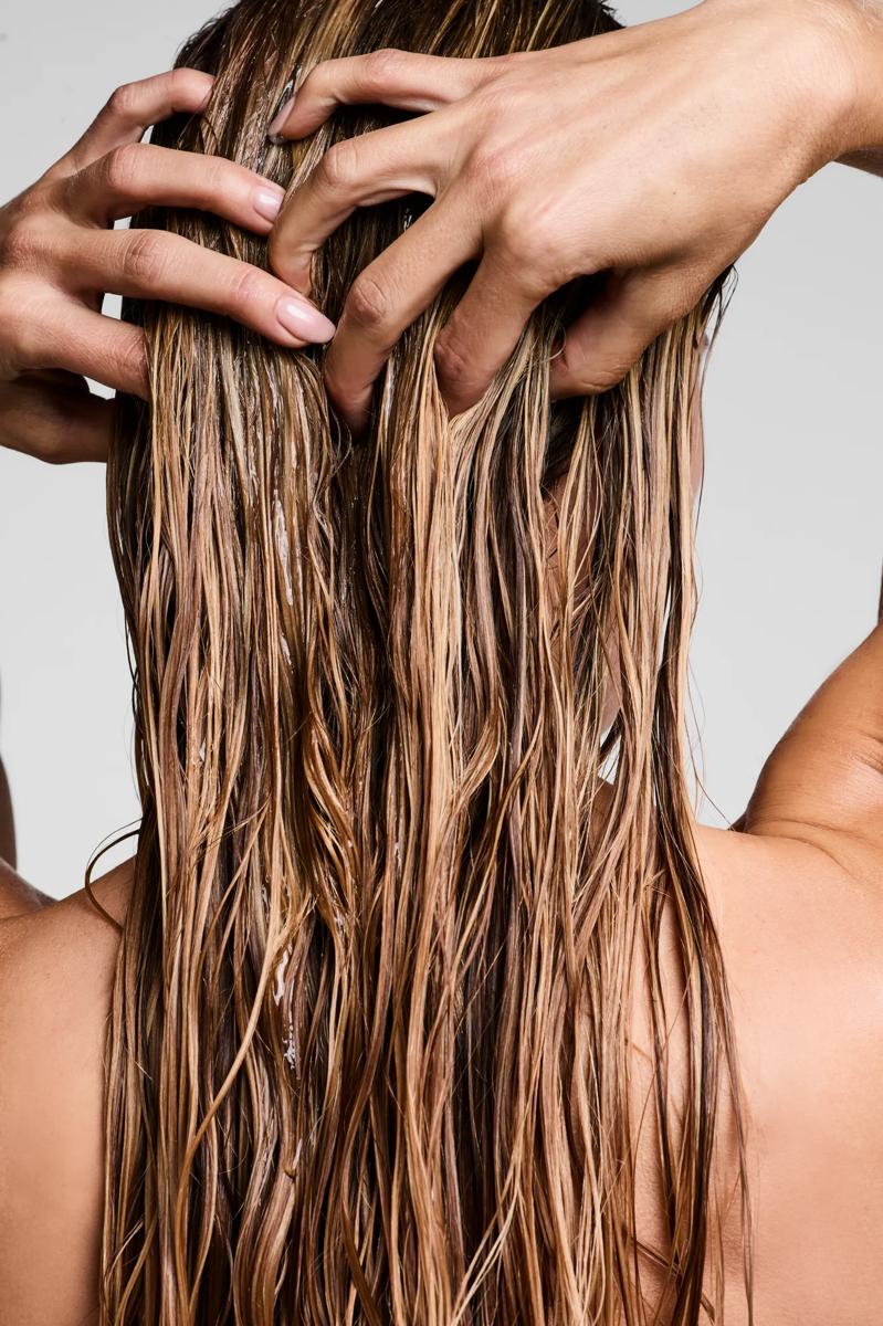 image of a woman distributing conditioner through her hair