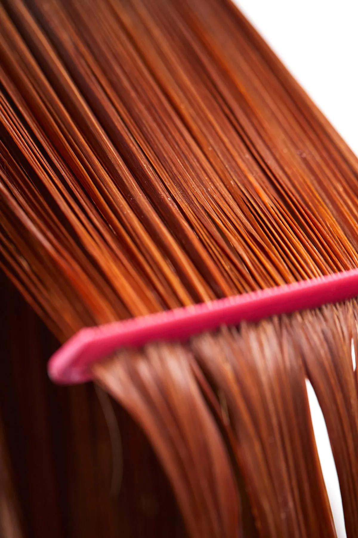image of a comb running through a woman's hair