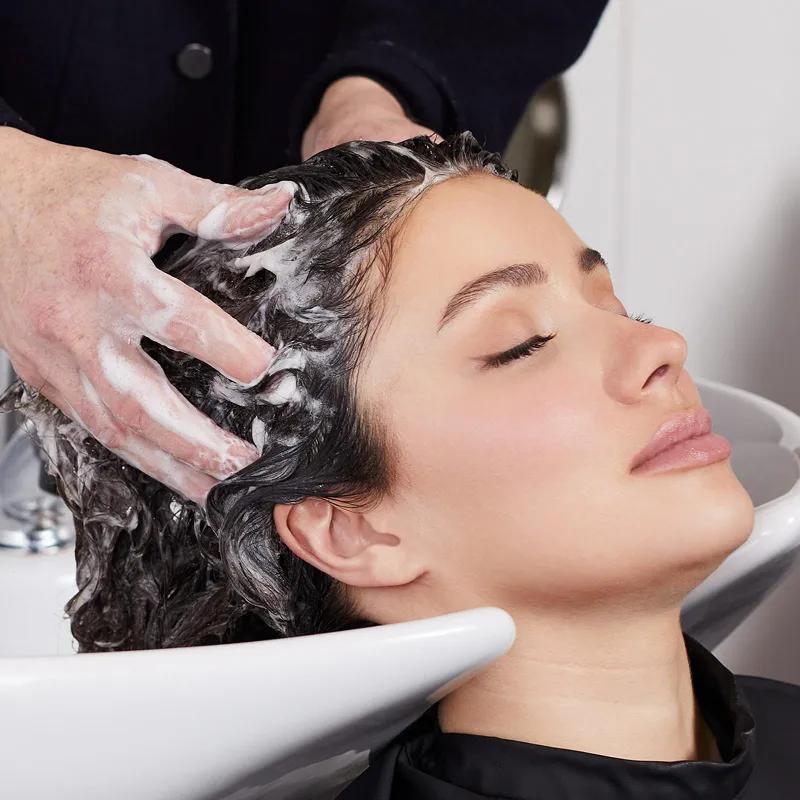 artistic image of model receiving a professional hair wash using Paul Mitchell Post-Color Shampoo