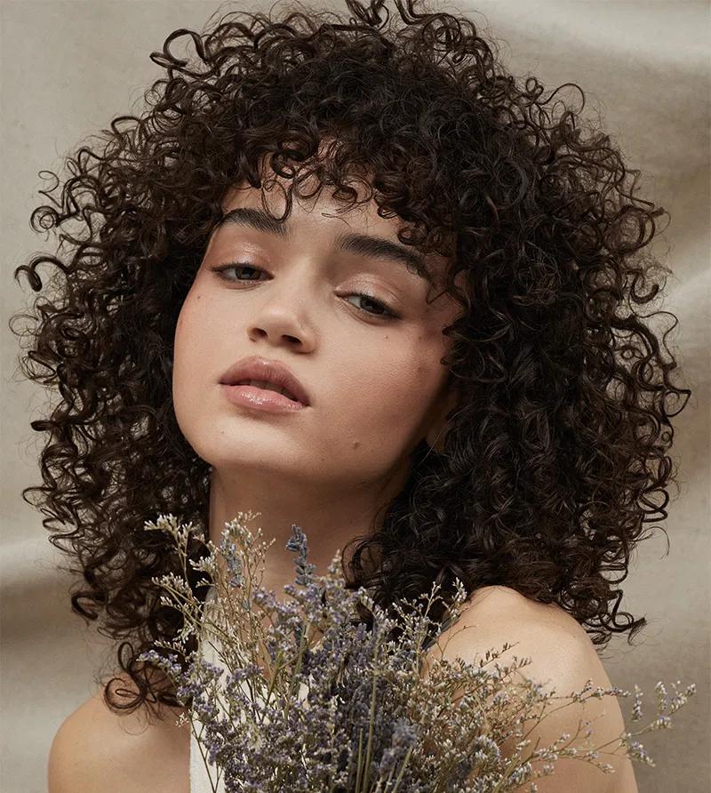 a woman with curly brunette hair